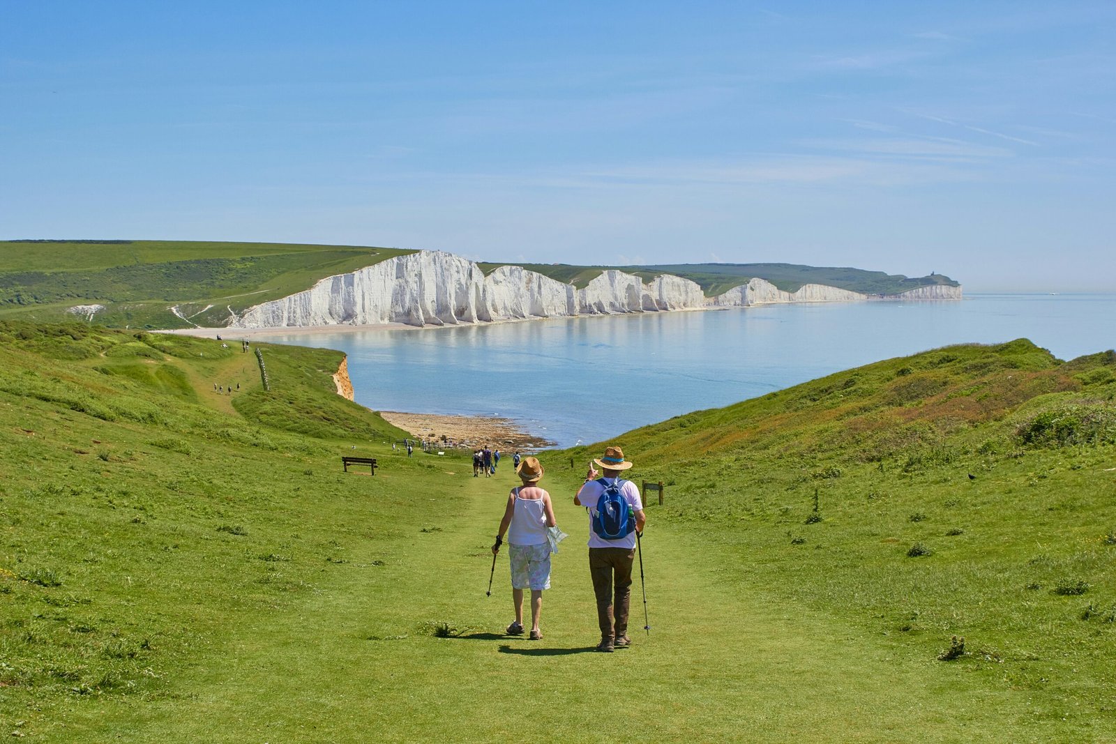 2 men standing on 2 men standing on green grass field near body of water during daytime